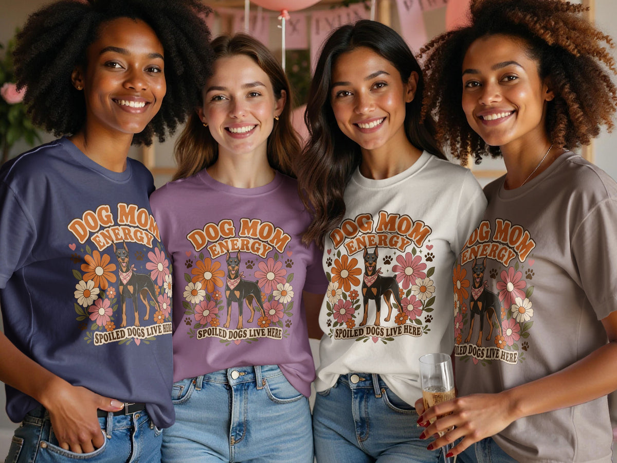 Four women wear graphic tees with "Dog Mom Energy" and a Doberman dog graphic.