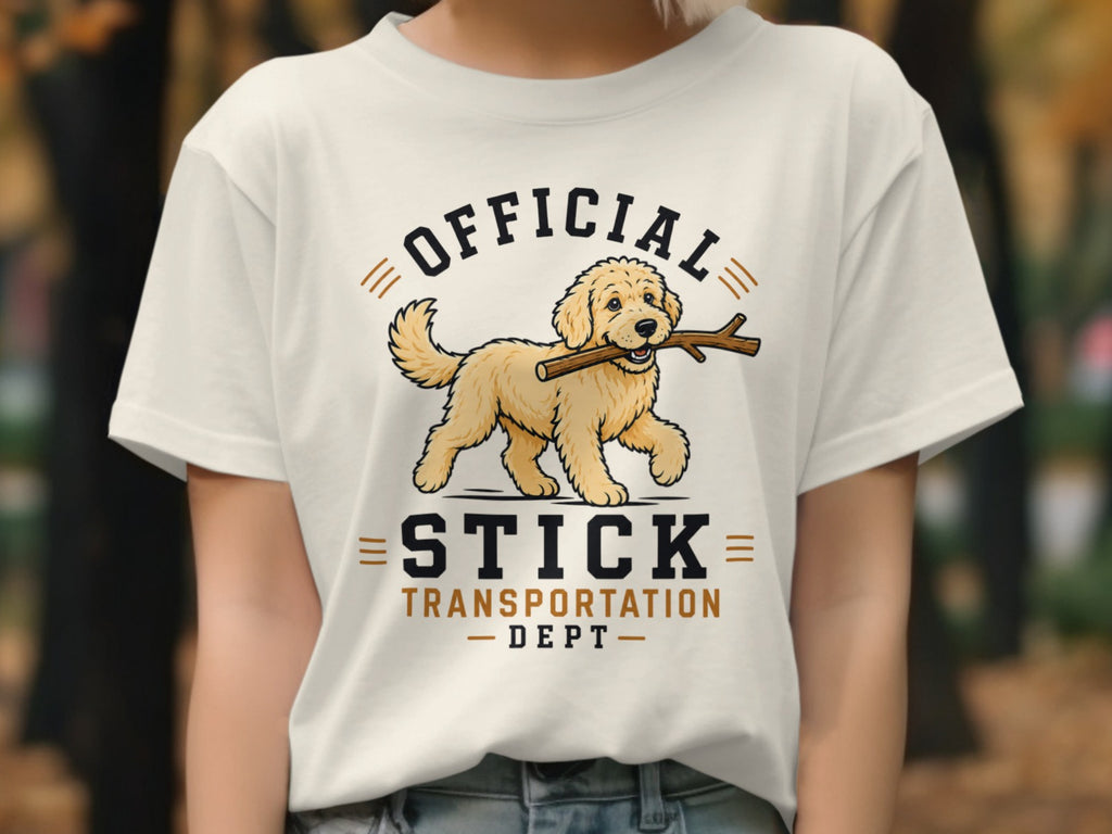 White t-shirt with a golden retriever carrying a stick, "Official Stick Transportation Dept." text.