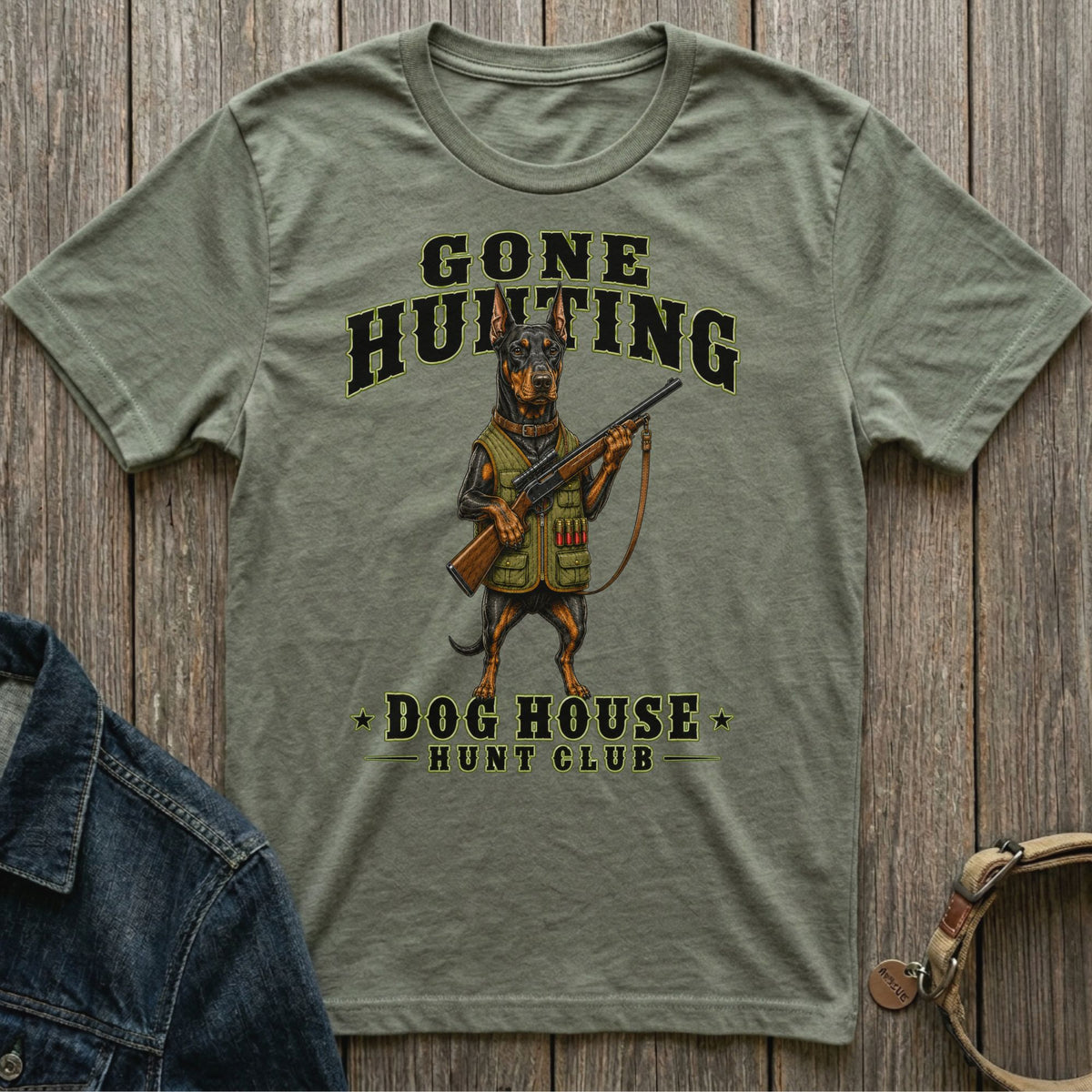 T-shirt with Doberman holding rifle, text reads "Gone Hunting Dog House Hunt Club".