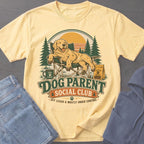 Yellow t-shirt with a Golden Retriever relaxing in a camping chair, "Dog Parent Social Club" text.