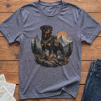 T-shirt with Rottweiler wearing backpack in mountain landscape art.