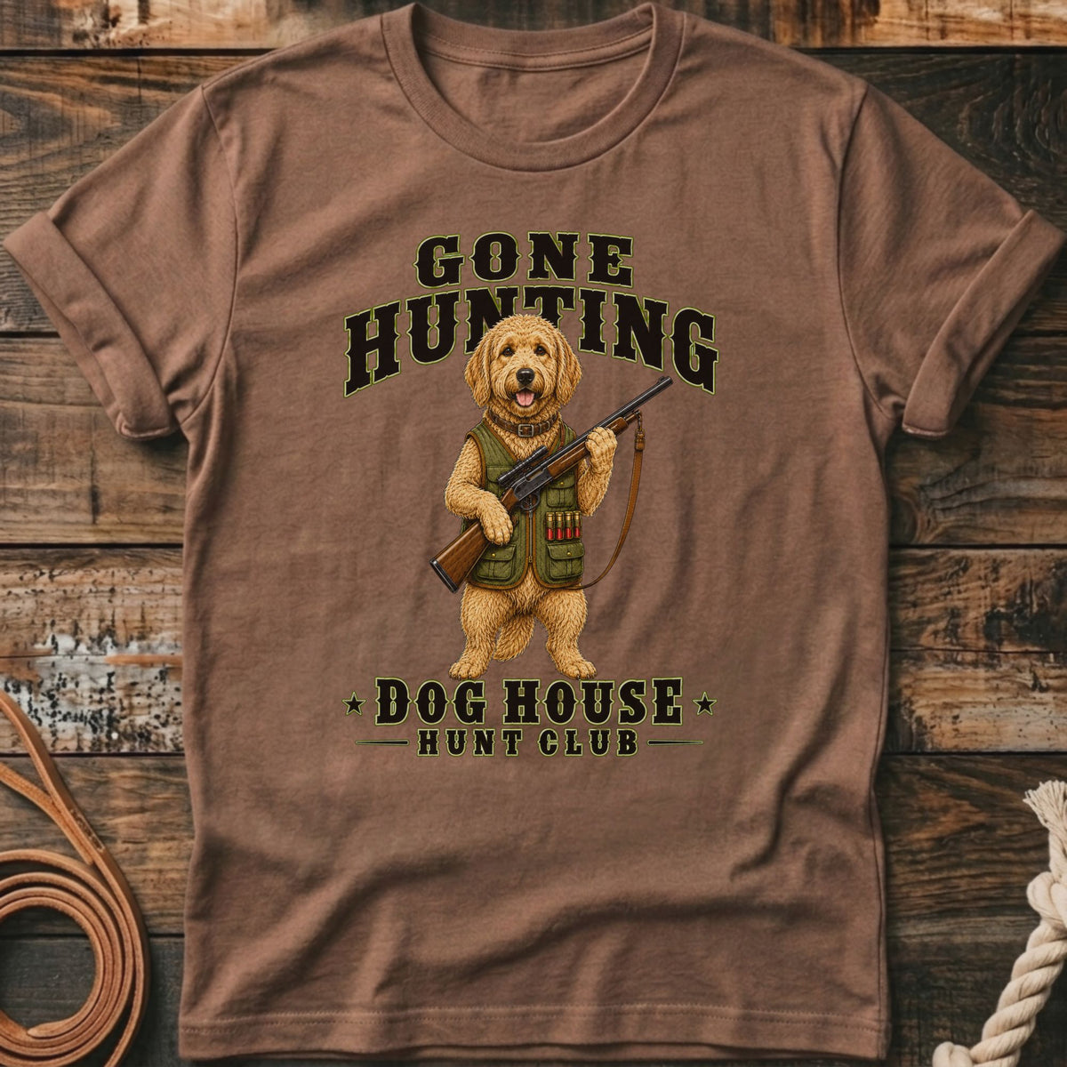 Brown t-shirt with a cartoon dog holding a rifle, text reads "GONE HUNTING" and "DOG HOUSE HUNT CLUB".