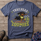 Dachshund wearing bandana runs with stick, text "TRAILHEAD ZOOMIES".