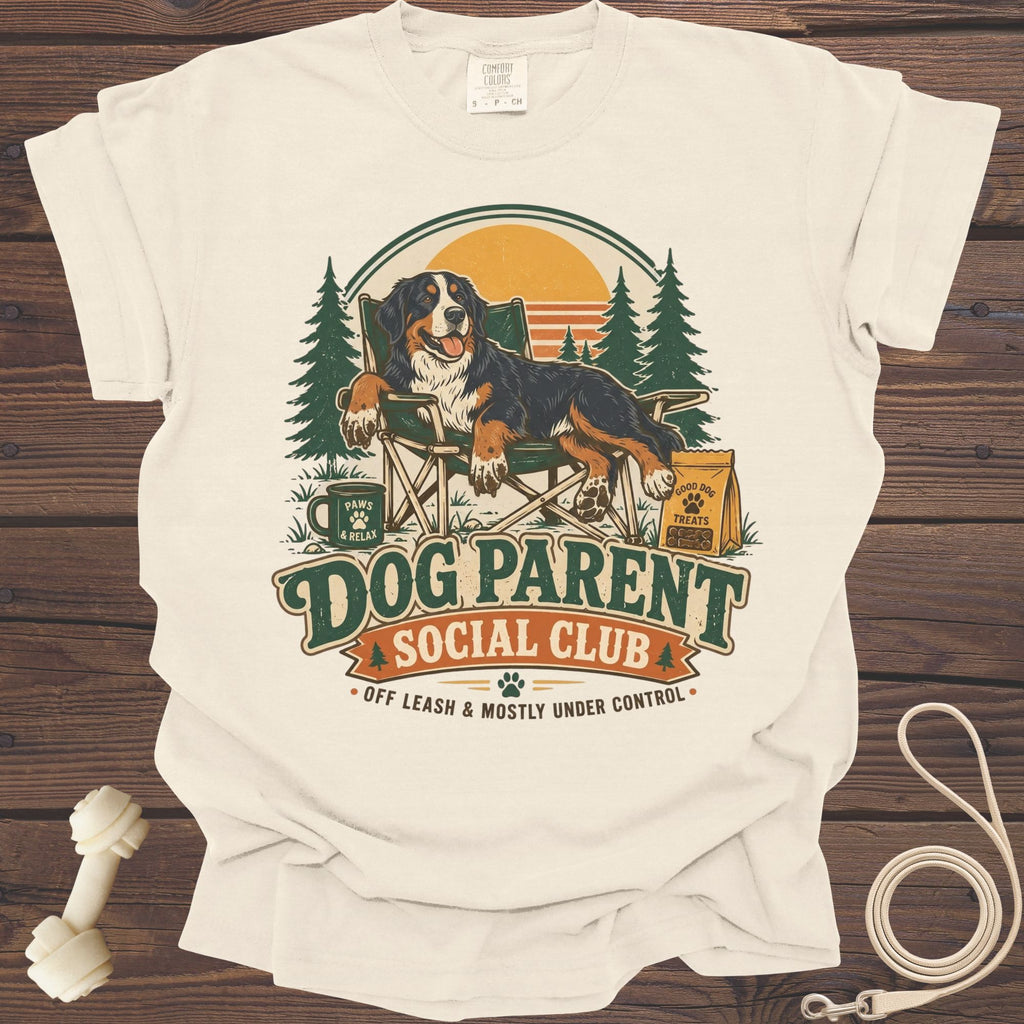 Bernese Mountain Dog in chair with "Dog Parent Social Club" text and woodland scene.