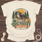 Bernese Mountain Dog in chair with "Dog Parent Social Club" text and woodland scene.