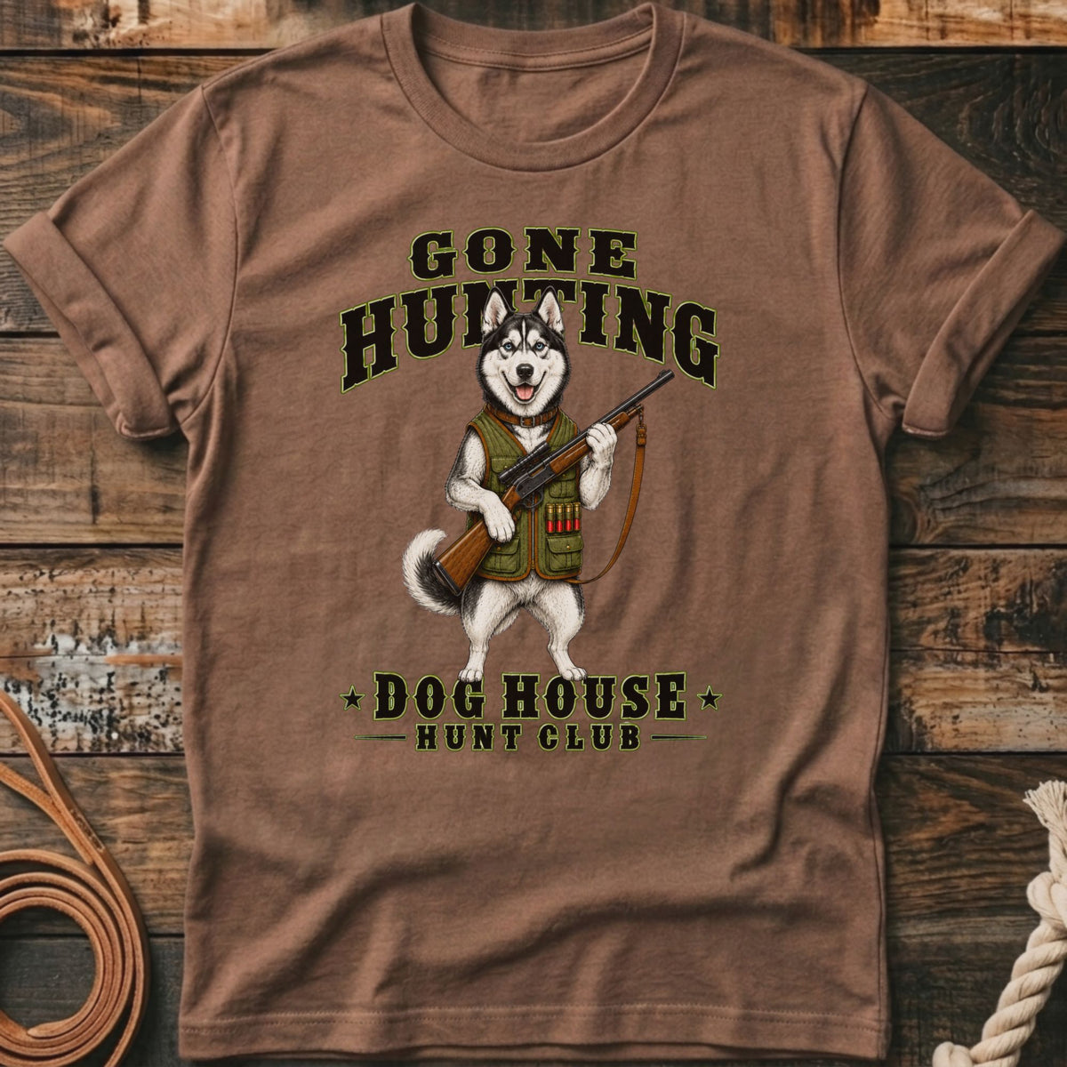 Brown t-shirt featuring a husky in hunting gear with a shotgun, text says "Gone Hunting Dog House Hunt Club".