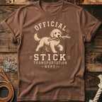 Brown t-shirt with graphic of dog carrying a stick and text "Official Stick Transportation - Dept"