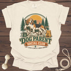 T-shirt with a beagle relaxing in a camping chair, text reads "Dog Parent Social Club."