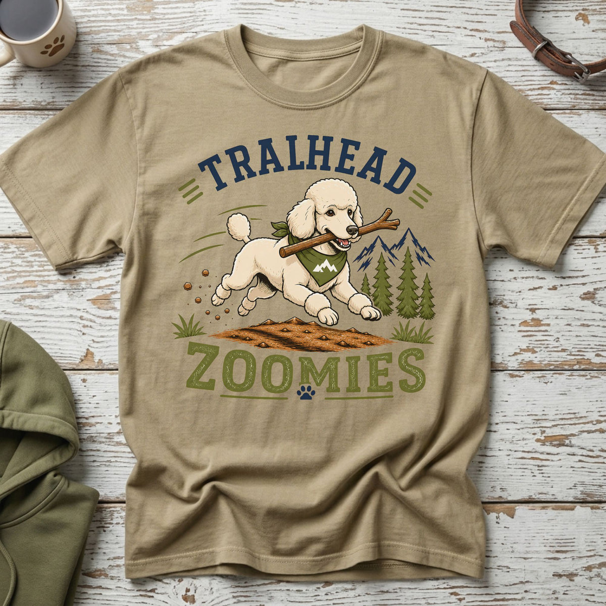 Poodle running with stick on dirt with "TRAILHEAD ZOOMIES" text.