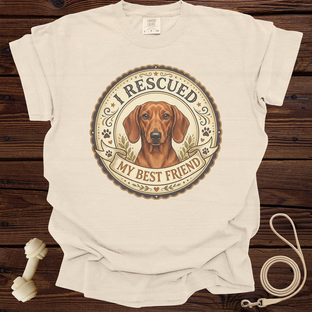 Cream t-shirt with a round graphic featuring a dachshund and text "I RESCUED MY BEST FRIEND".