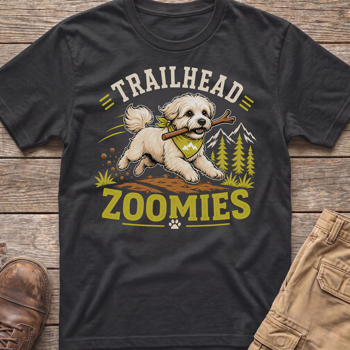 White dog with stick on t-shirt, text "TRAILHEAD ZOOMIES", mountains, trees