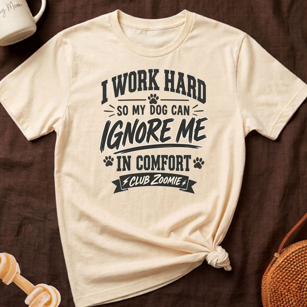 Cream t-shirt with black text "I WORK HARD SO MY DOG CAN IGNORE ME IN COMFORT CLUB ZOOMIE".