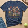 Navy t-shirt with a Yorkshire terrier surrounded by tulips and the text "Paws in Bloom."
