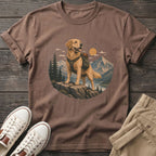 Golden retriever with backpack standing on rock in mountain landscape graphic on brown t-shirt.