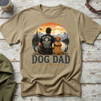 T-shirt with "DOG DAD" and graphic of man and dog by lake and mountains.
