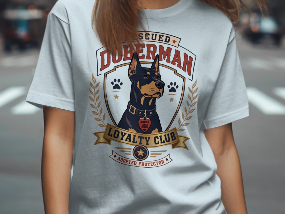 "Rescued Doberman Loyalty Club Adopted Protector" t-shirt graphic.