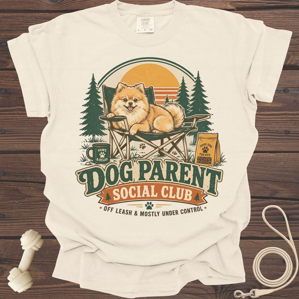 Cream t-shirt graphic with a Pomeranian on a chair, "Dog Parent Social Club" text.