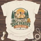 Cream t-shirt graphic with a Pomeranian on a chair, "Dog Parent Social Club" text.