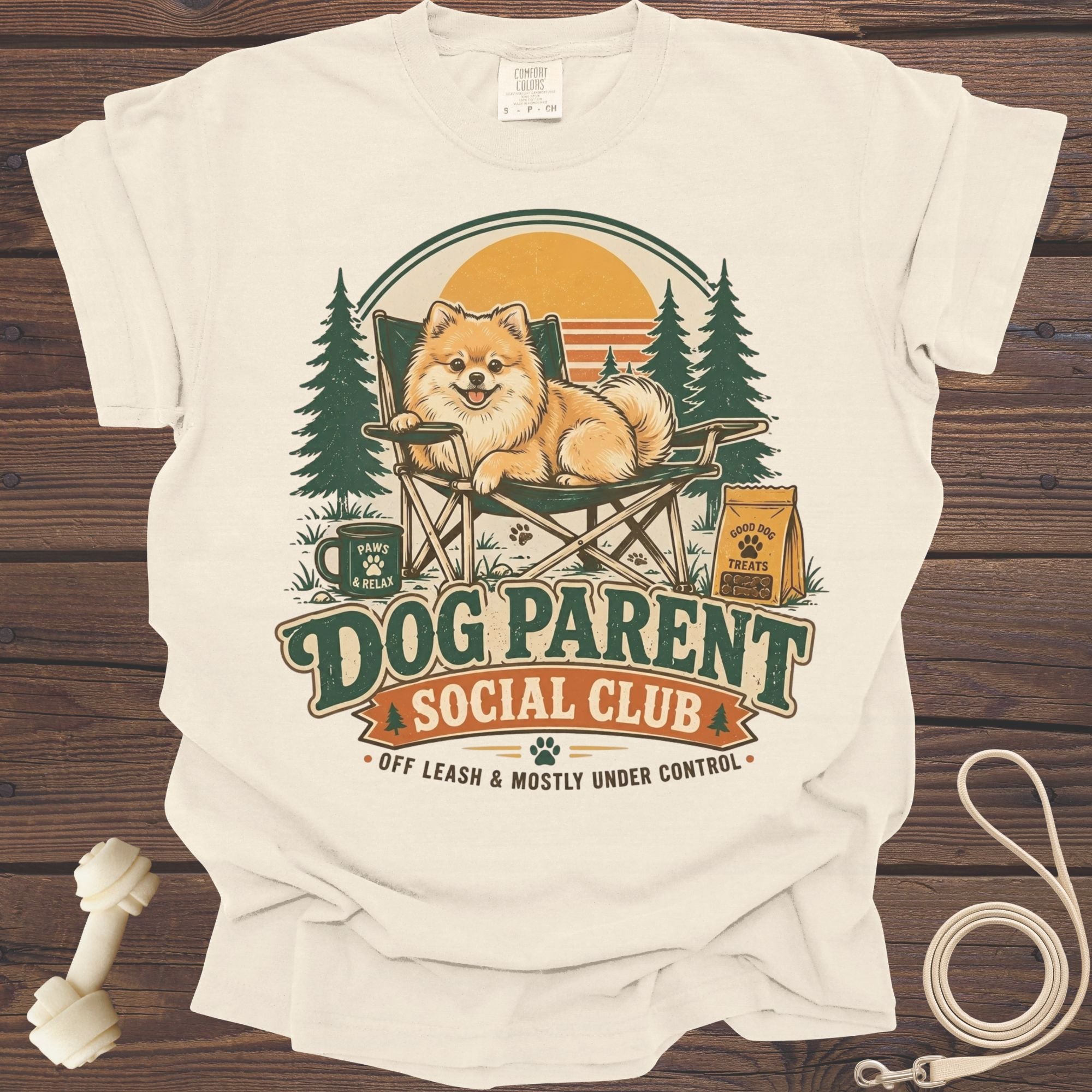 Cream t-shirt graphic with a Pomeranian on a chair, "Dog Parent Social Club" text.
