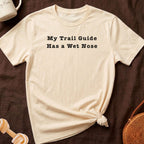 Cream t-shirt with black text that reads "My Trail Guide Has a Wet Nose."