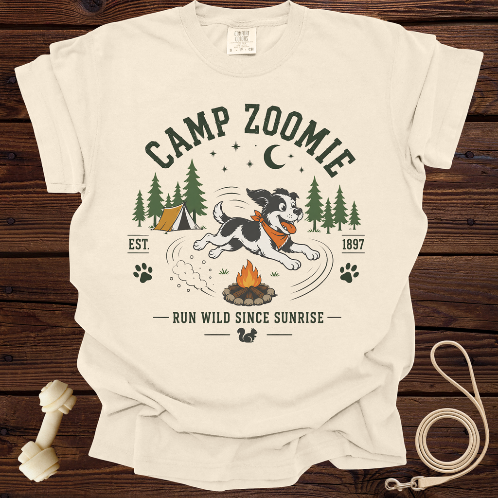 Cream t-shirt with "Camp Zoomie" design featuring a dog running near a campfire and tent.