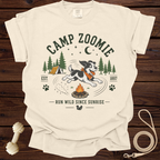 Cream t-shirt with "Camp Zoomie" design featuring a dog running near a campfire and tent.