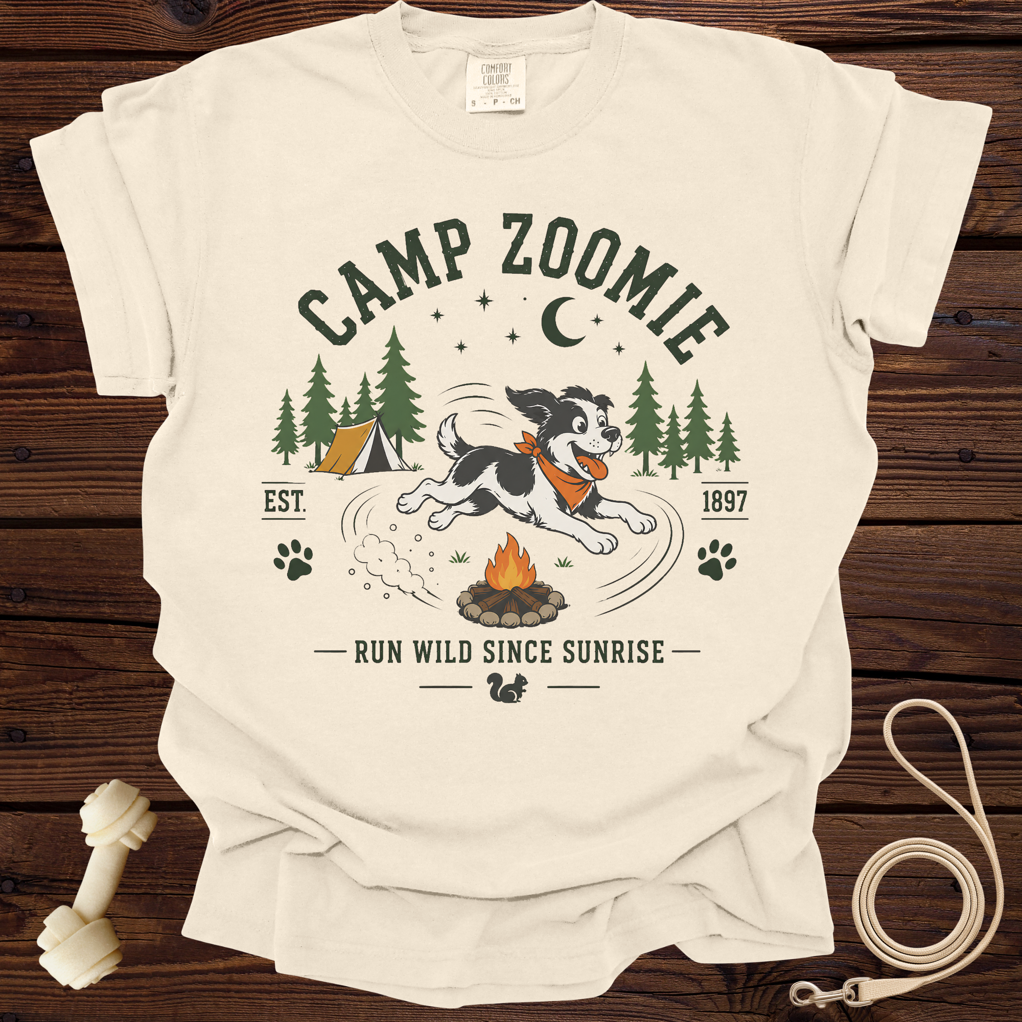 Cream t-shirt with "Camp Zoomie" design featuring a dog running near a campfire and tent.