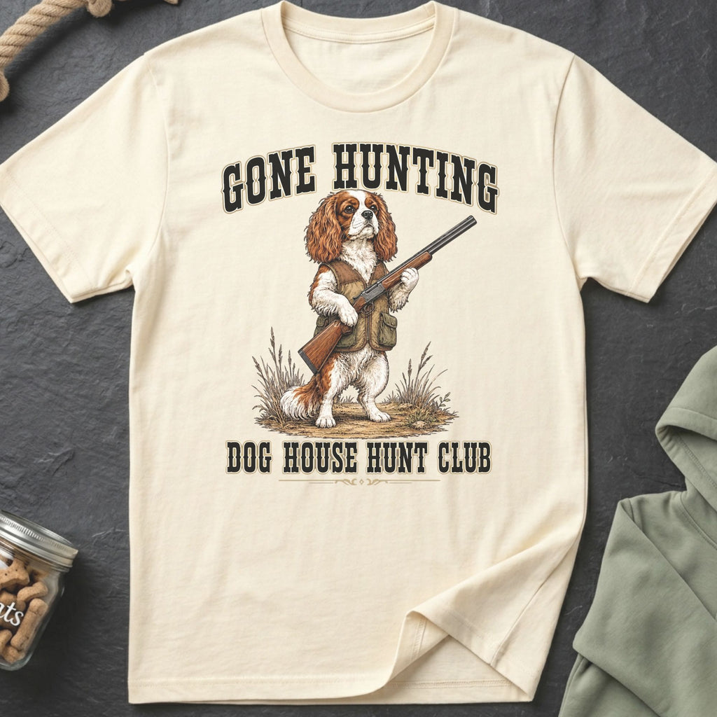 Cream t-shirt with a Cavalier King Charles Spaniel holding a shotgun, text reads Gone Hunting Dog House Hunt Club.