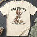 Cream t-shirt with a Cavalier King Charles Spaniel holding a shotgun, text reads Gone Hunting Dog House Hunt Club.