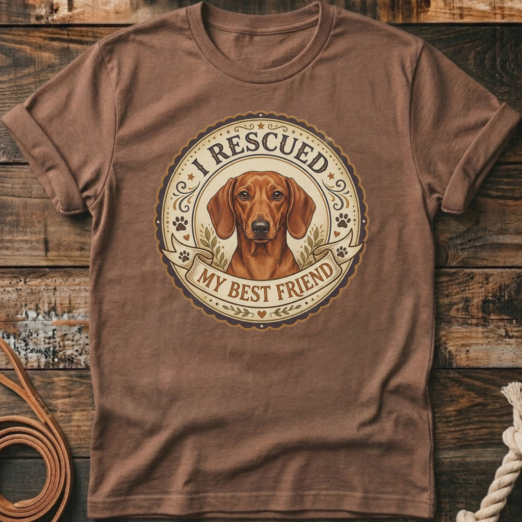 Brown t-shirt with a round graphic of a dachshund, reading "I Rescued My Best Friend".