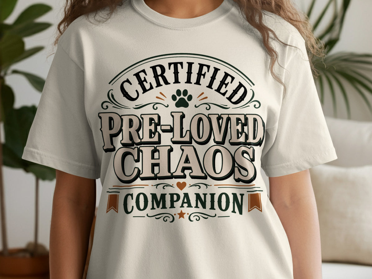 Light beige t-shirt with "Certified Pre-Loved Chaos Companion" text and paw print.