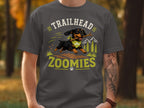 Dachshund with stick on shirt text "TRAILHEAD ZOOMIES" and mountain graphics.