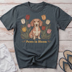 Dachshund sitting among tulips with text "Paws in Bloom".
