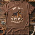 German Shepherd with stick on shirt reading "Official Stick Transportation Dept".