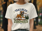Boxer dog with stick on t-shirt with text "Trailhead Zoomies" and mountain scenery.