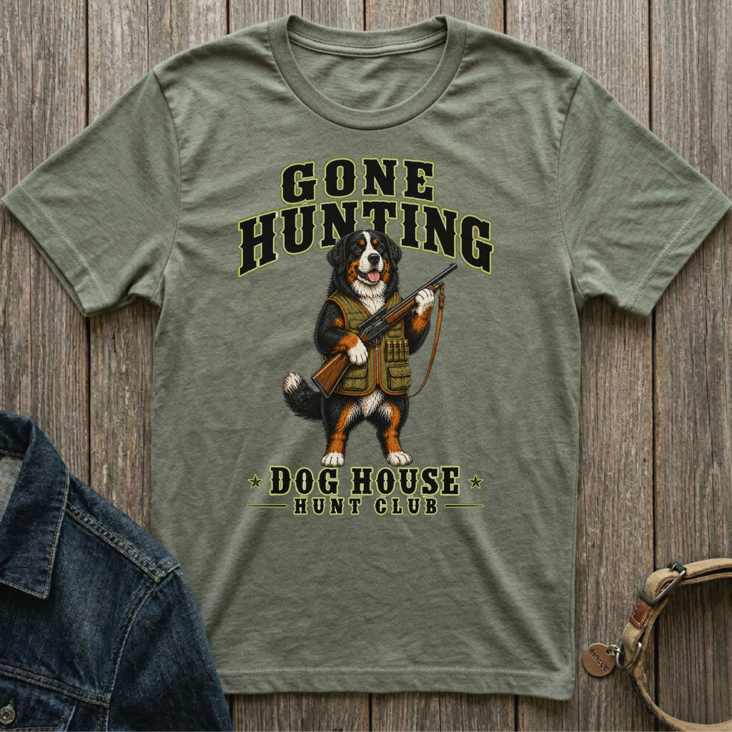 Bernese Mountain Dog wearing hunting vest holds rifle; "GONE HUNTING" and "DOG HOUSE HUNT CLUB" text.