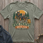 Green t-shirt with a Doberman on a camping chair, "Dog Parent Social Club" text.