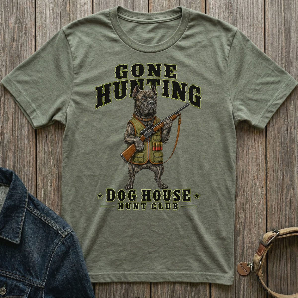 Olive green t-shirt with a dog in hunting gear holding a rifle and text.