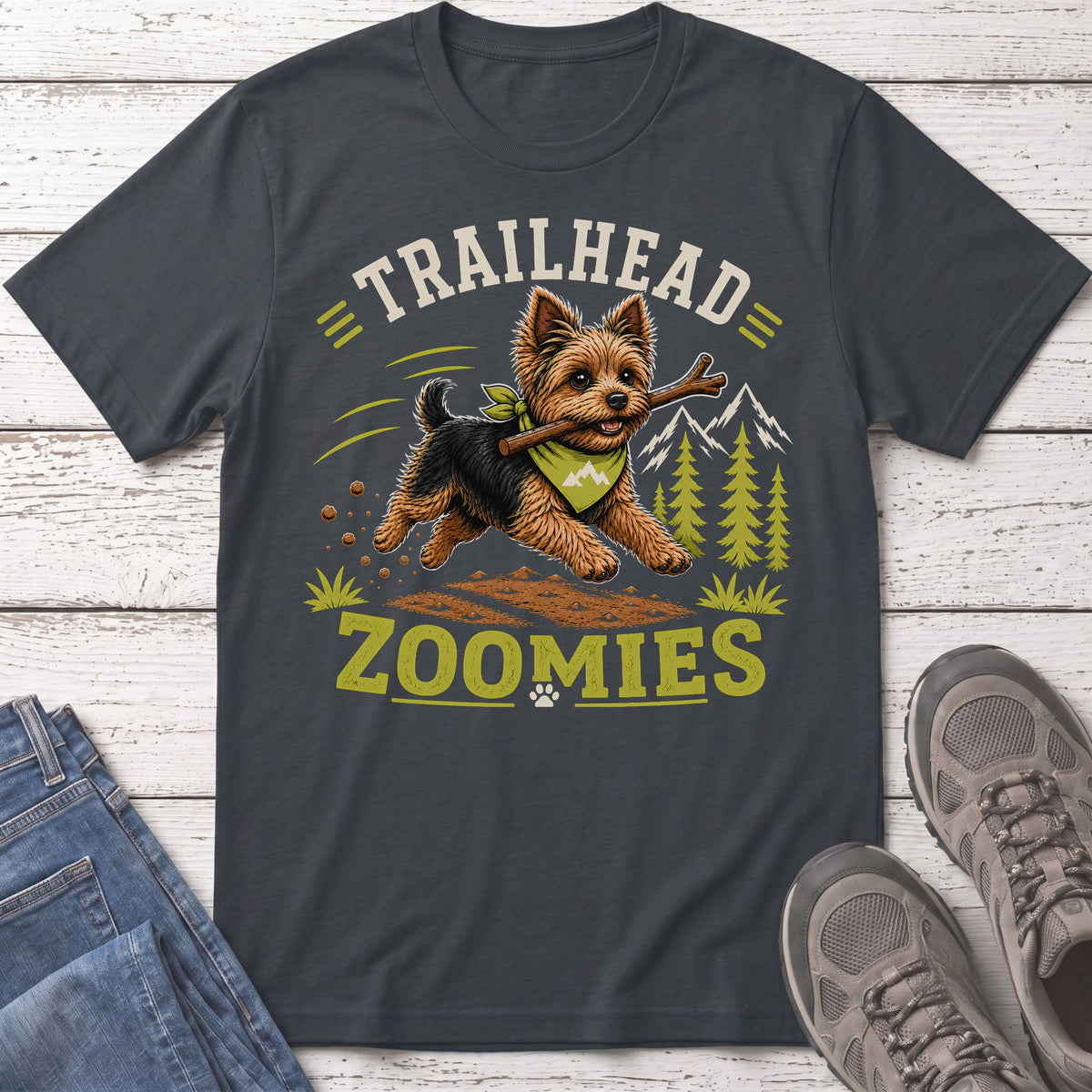 Yorkshire terrier with stick and bandana, text "TRAILHEAD ZOOMIES" on dark t-shirt.