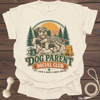 T-shirt graphic with a dog lounging in a camping chair, "Dog Parent Social Club" text.