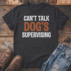 Black t-shirt with "CAN'T TALK DOG'S SUPERVISING" text.