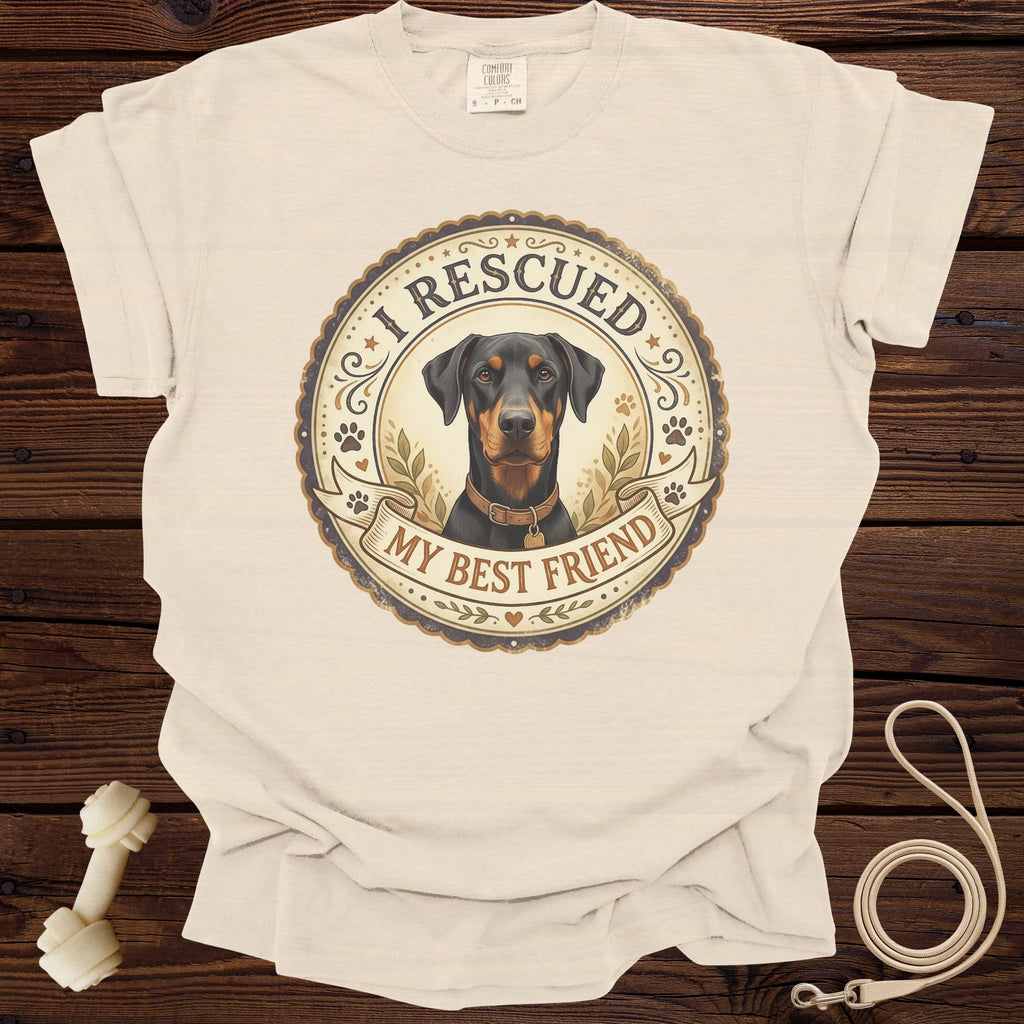 Doberman graphic on cream t-shirt with text "I rescued my best friend."