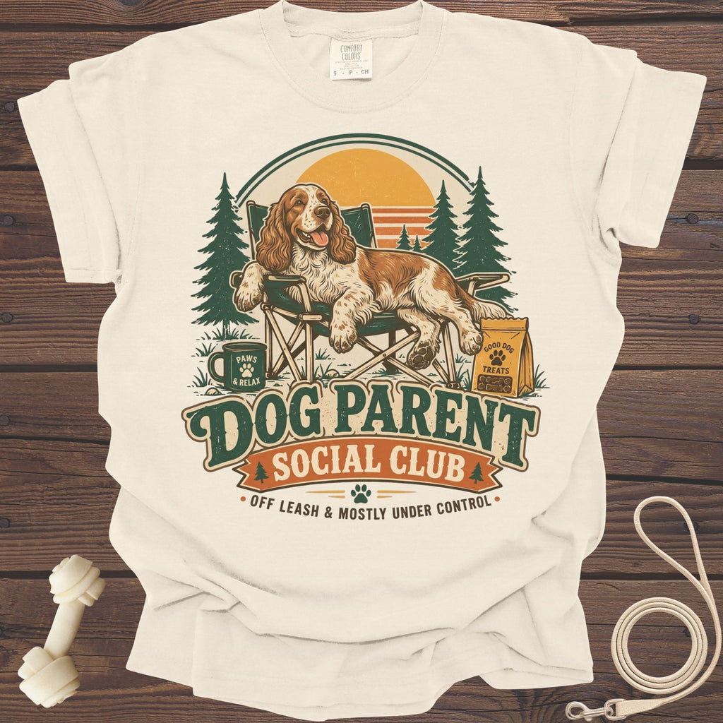A dog relaxes in a chair with text "Dog Parent Social Club" and trees.