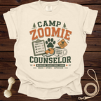 Camp Zoomie Counselor graphic tee with "Managing Chaos Since Dawn" text.