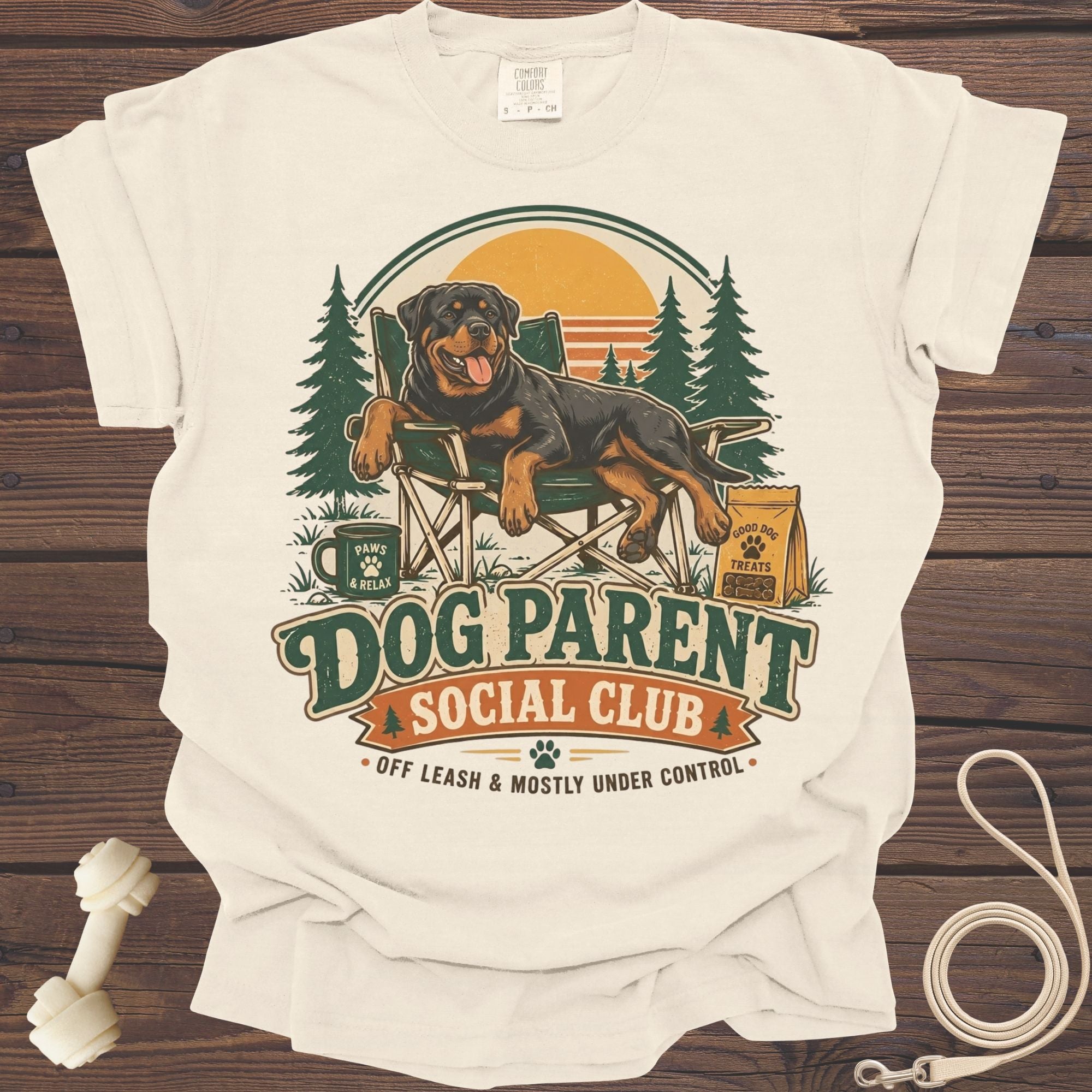 Rottweiler in a chair with "Dog Parent Social Club" text and outdoor scene.