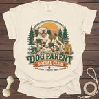 Cream t-shirt with dog sitting in a camping chair with "Dog Parent Social Club" text.