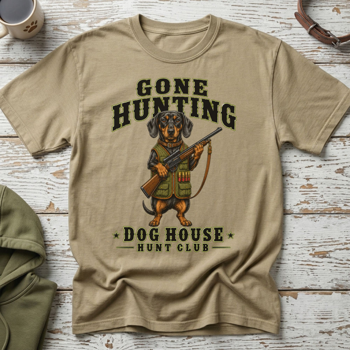 T-shirt with dachshund in hunting gear holding a rifle, text "Gone Hunting Dog House Hunt Club".