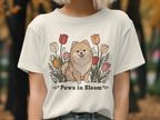 Cream t-shirt with a beige Pomeranian dog surrounded by tulips and text "Paws in Bloom".