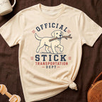 Cream t-shirt with yellow lab carrying a stick, text reads "Official Stick Transportation Dept".
