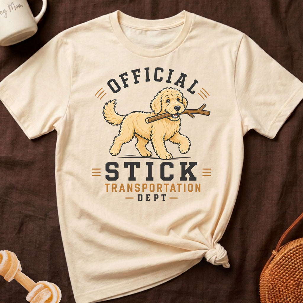 Cream t-shirt with cartoon dog carrying stick and text "Official Stick Transportation Dept".